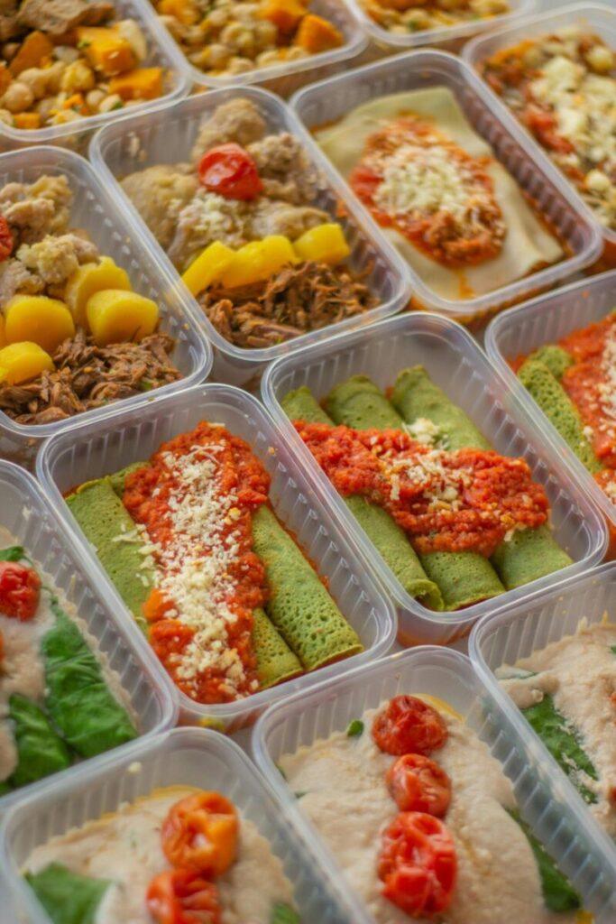 An assortment of healthy, colorful meal prep boxes featuring vegetables, grains, and proteins.